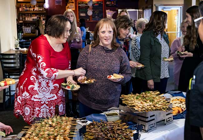 Guests enjoy Minnesota Catering at a lively buffet during a social gathering in a local restaurant.