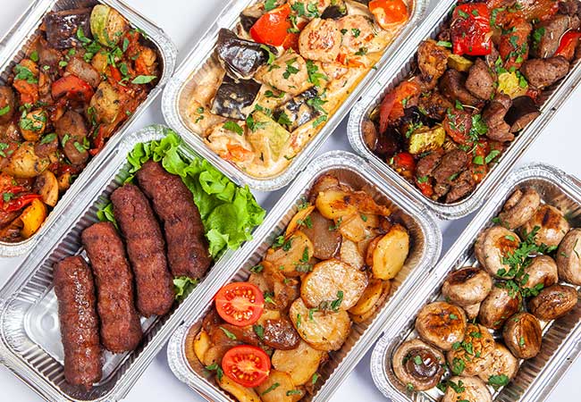 Complete Catering offers grilled meats, potatoes, mushrooms, and veggies in aluminum containers.